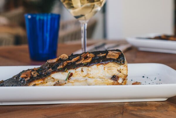 Dónde comer pescado en Suances. Plato de Rodaballo y una copa de vino blanco