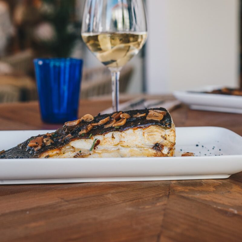 Dónde comer pescado en Suances. Plato de Rodaballo y una copa de vino blanco